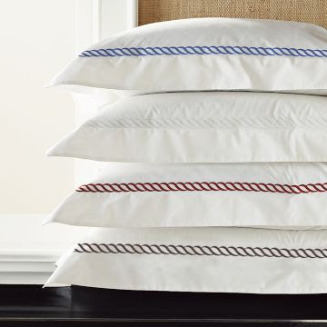 White bedding with a red, white, blue or brown rope twist pattern from William Sonoma Home