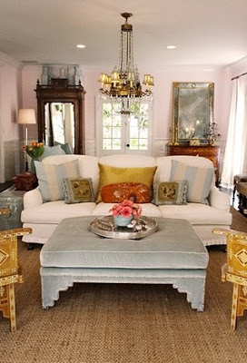 Light blue velvet ottoman in a living room with a white tight back upholstered sofa and sea grass rug by Windsor Smith