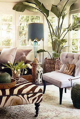 A tufted slipper chair and upholstered zebra print ottoman in a sitting room by Windsor Smith 