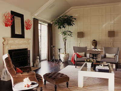 Living room with decorative molding on the main wall, marble fireplace and tufted armchair by Betsy Burnham