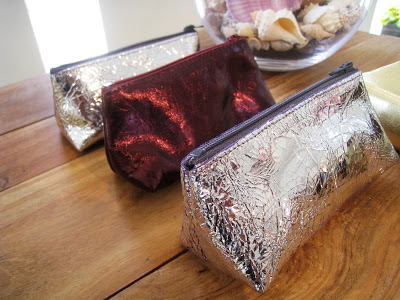 Small metallic make up cases in silver, plum and pewter from Persimmon
