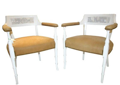 Two carved chairs with faux bamboo legs painted white, cane backs and upholstered in caramel leather with nail head trim from Pieces