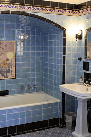 Guest bathroom with blue and black tiles and a white pedestal sink