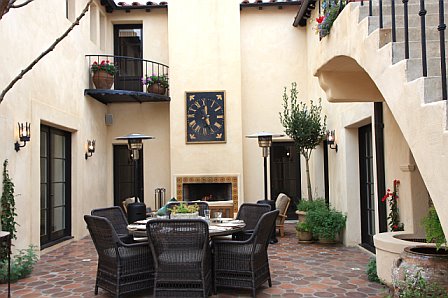 Kitchen courtyard is built out to include a tile patio and outdoor fireplace after remodeling