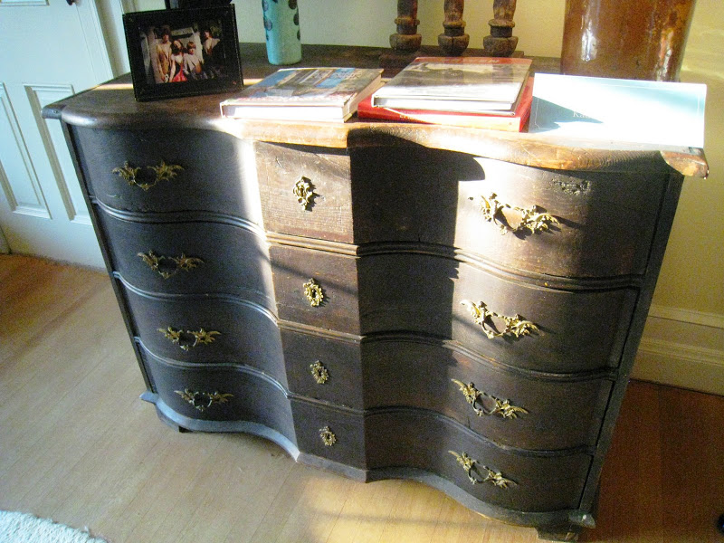 Dark stained wood serpentine dresser with brass pulls and keyholes