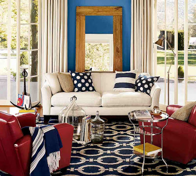 Living room with a blue and off white Chain Rug, red leather chairs, a white sofa and blue and white accessories