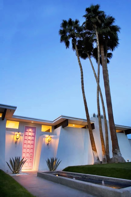 Exterior of a Palm Springs home with a pink front door at night