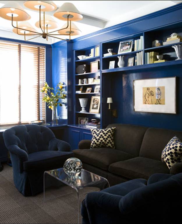 Glossy dark blue living room with built in bookshelves, overstuffed navy armchairs and a brown sofa