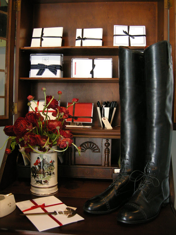 Black boots in front of a shelf with neatly wrapped stationary 
