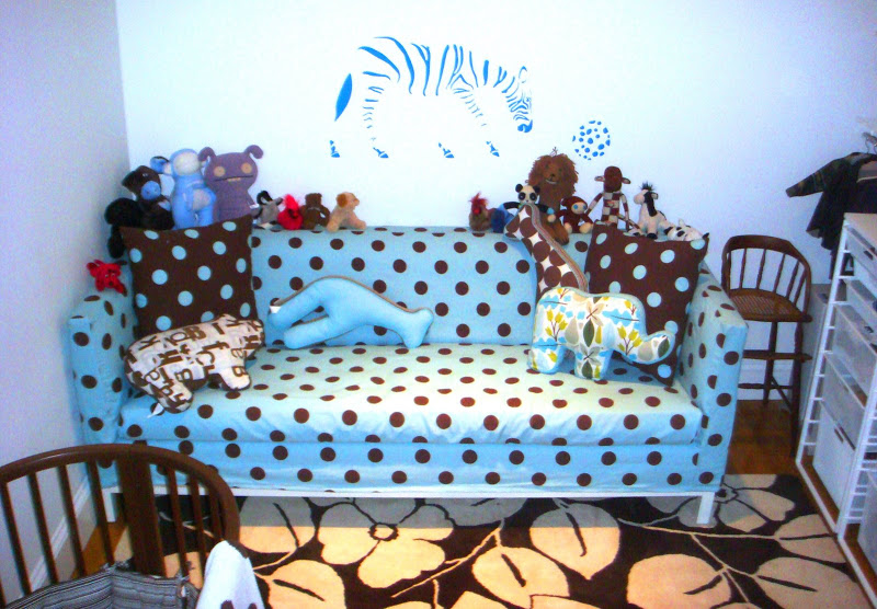 Blue and white polka dot Jonathan Adler Lampert Sofa in a nursery with lots toys and pillows