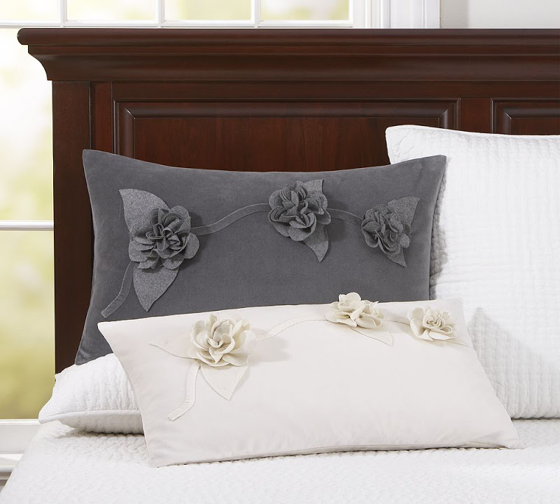 White and grey rectangular accent pillows in velvet with flower applique rosettes from Pottery Barn