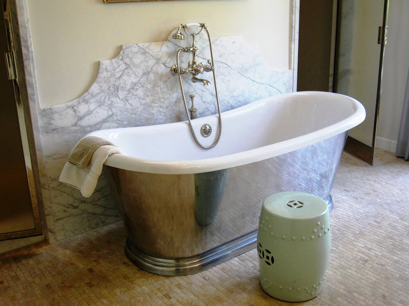 Cast iron tub with polished metal exterior in Waterworks