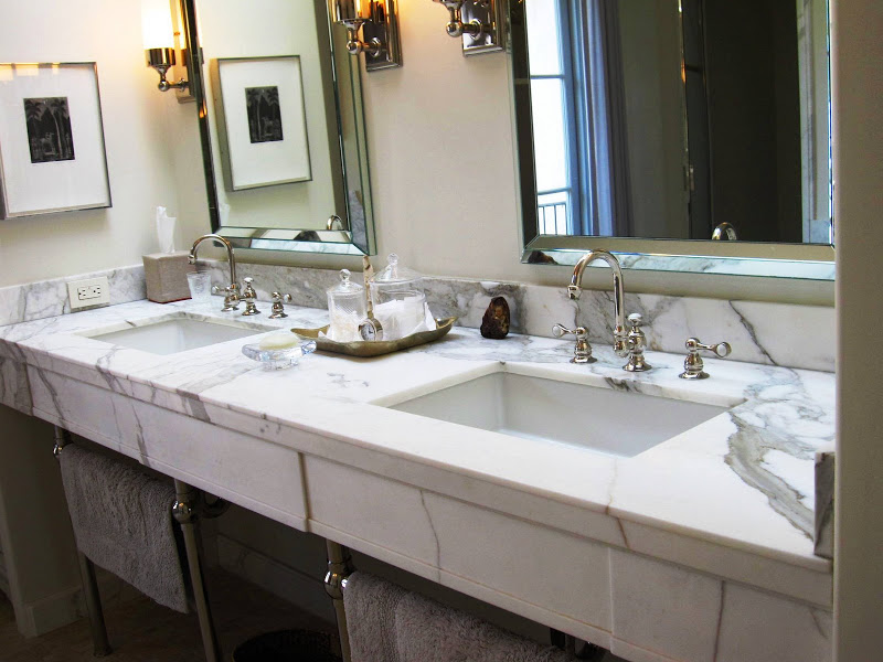 Bathroom with white Carrara marble vanity, double undermount sinks, polished chrome fixtures, faucets and scones and mirrors