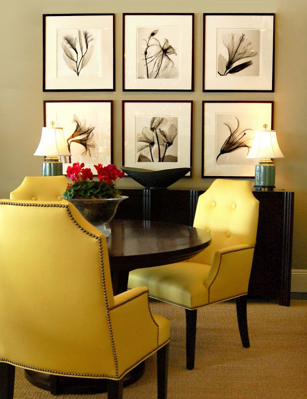 Dining room with bright yellow tufted chairs around a round dark wood table