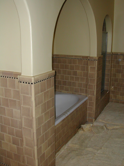Bathroom in a Hancock Park home with tile details and an arch over the bath and carpeted floor