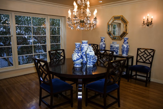 Dining room in a Hancock Park home after remodeling with wood floor, paned windows, dark wood table and Chippendale style chairs and bright wallpaper