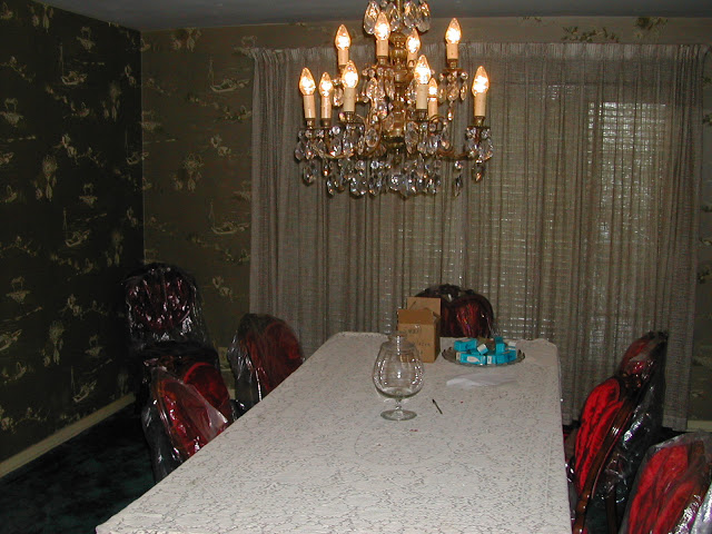 Formal dining room in a Hancock Park home prior to remodeling with dark wallpaper and wall to wall carpet
