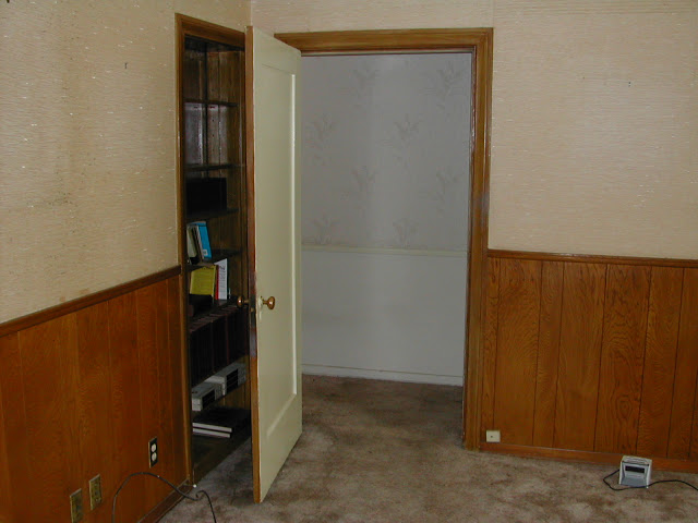 Downstairs room in a Hancock Park home prior to remodeling with wood paneling and wall to wall carpeting