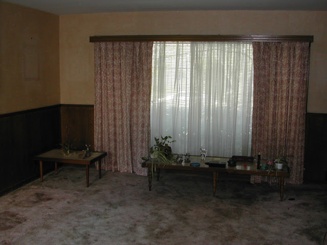 Room in a Hancock Park home before remodeling with a large window and wall to wall carpeting