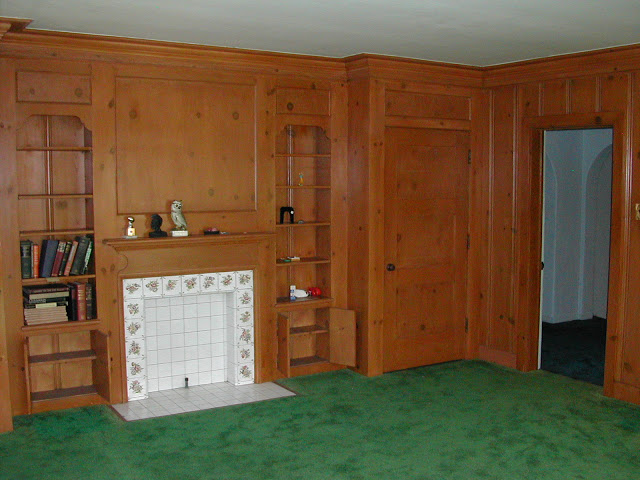Library in a Hancock Park home with bright green carpet and wood paneled walls before remodeling