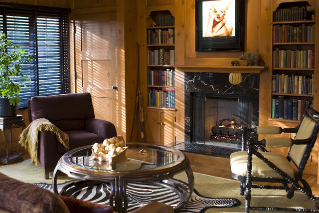 Library in a Hancock Park home after remodeling with refurbished wood paneling and a marble fireplace
