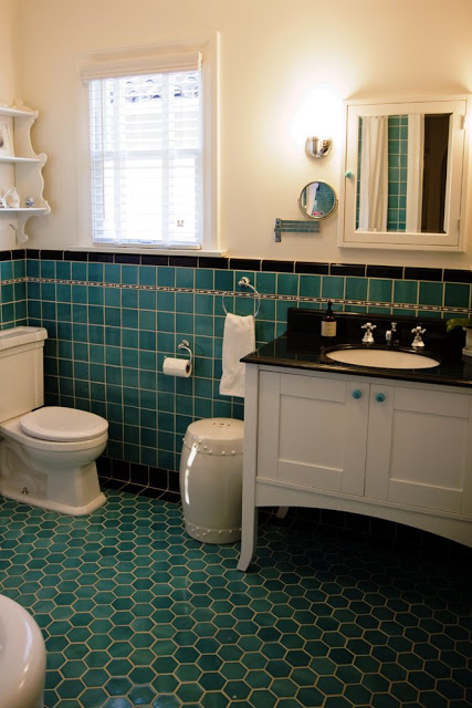 Guest bathroom after remodeling with vintage inspired turquoise blue square tiles, large blue hexagon tiles on the floor, black counter top and a white vanity sink