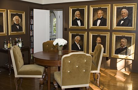 Game room in a Hancock Park home after remodeling with portraits of past presidents and wood floor 