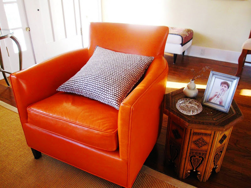 Bright orange leather armchair from Crate and Barrel and a Moroccan side table in a living room in a Venice Beach home