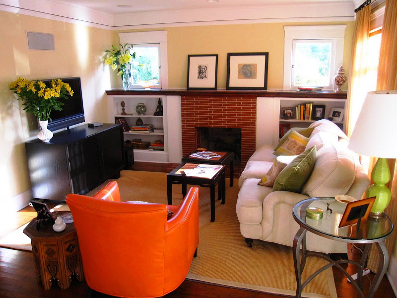 Yellow living room in a Venice Beach home with an orange leather armchair, brick fireplace with white built in bookcase, white sofa and a Moroccan inspired side table