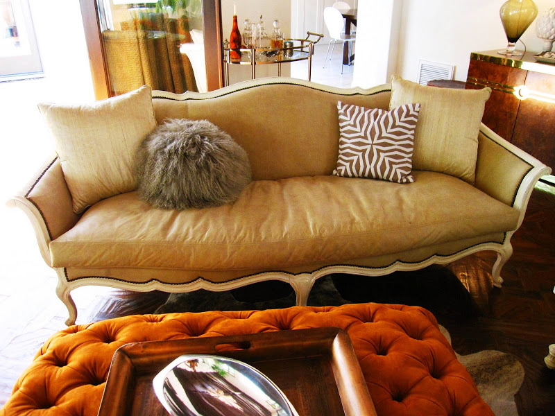 Traditional caramel settee with wood trim and a round Flokati throw pillow in an LA living room