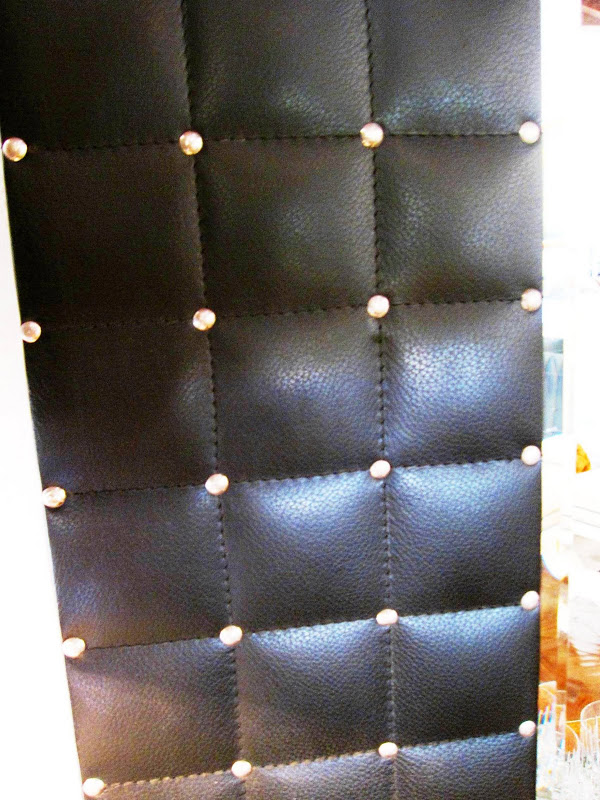 Close up of a modern quilted or tufted leather mirror in a living room in a Los Angeles home