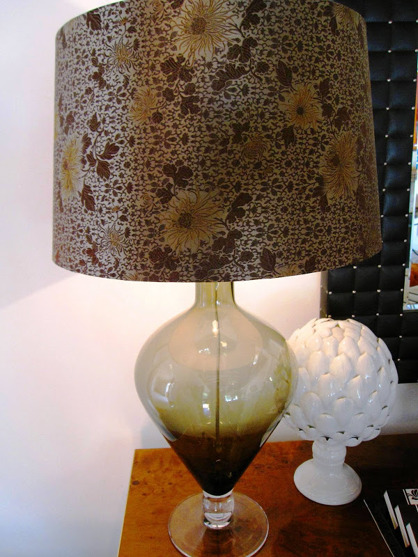 Green faded glass urn table lamp with a brown floral lampshade in a living room in Los Angeles