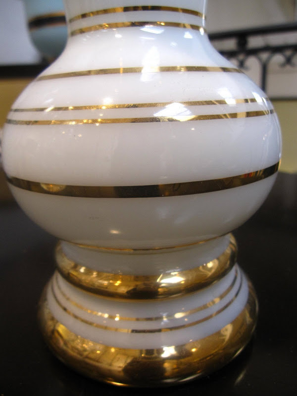 Close up of a white porcelain vase with gold band stripes from Plantation
