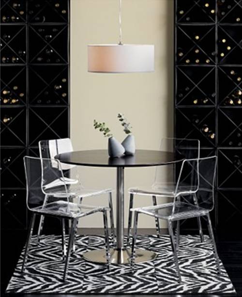 Four simple acrylic and chrome dining chairs from cb2 surround a small wood and metal cafe dining table.