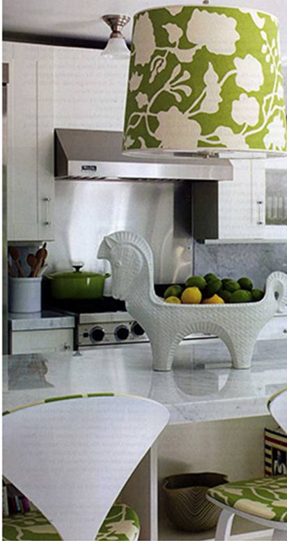 Modenr white kitchen by Jonathan Adler with a dome pendant light over an island made with a bold green and white printed fabric