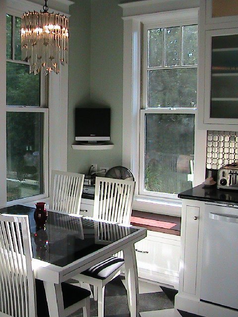 Kitchen after remodeling with a breakfast nook with a white table with a black insert