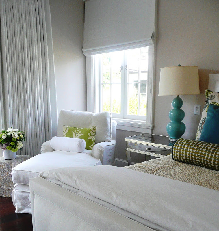 Bedroom by Brooke Giannetti with a white chaise lounge, mirrored nightstand, blue table lamp and an upholstered bed