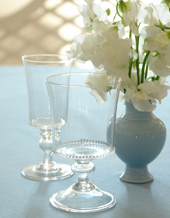 Two wine glasses with gently flared rims and hobnail stud design on the base from Carolyne Roehm