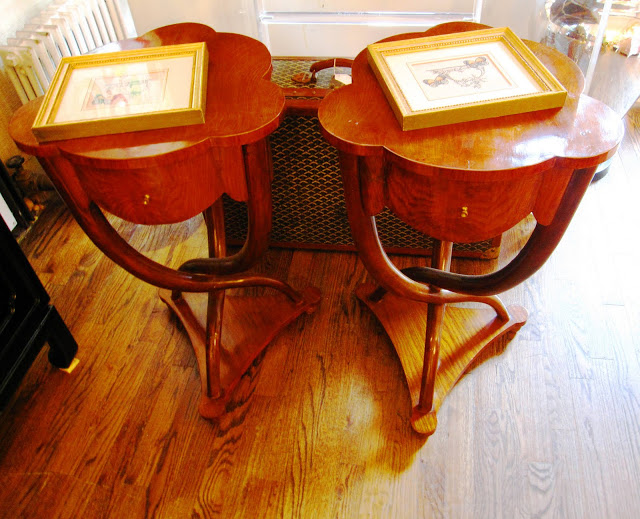 Two wooden scalloped side tables inside the Elizabeth Bauer store