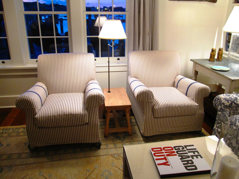 Two blue and white striped upholstered armchairs under a picture window at the Great Harbor Yacht Club
