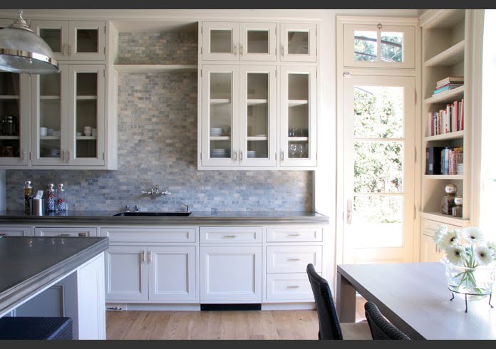 Kitchen with grey mosaic subway tile backsplash, white cabinets and drawers and grey zinc countertops