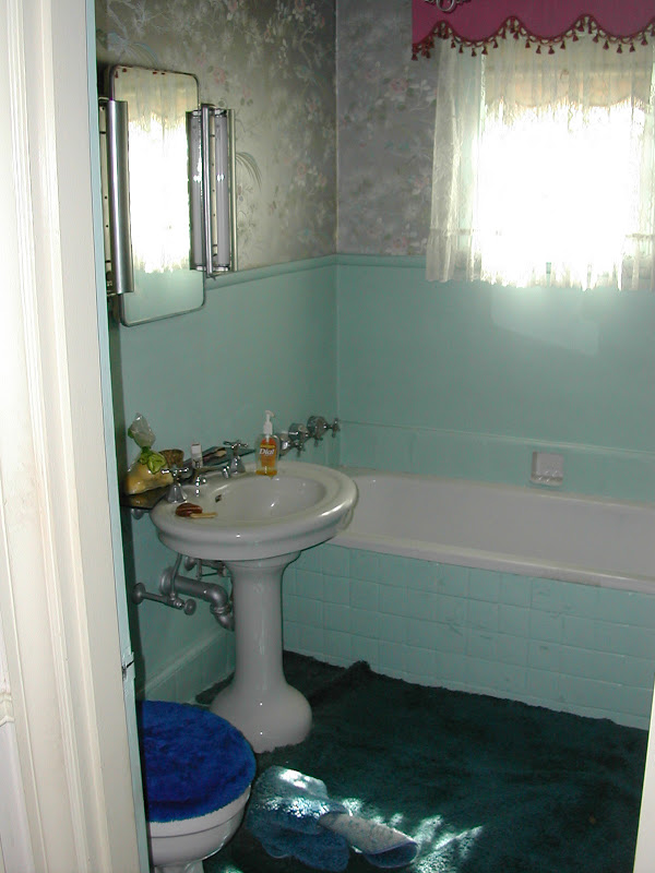 Bathroom before Newman & Wolen Design's remodeling with blue carpet, blue tiling and grey metallic wallpaper