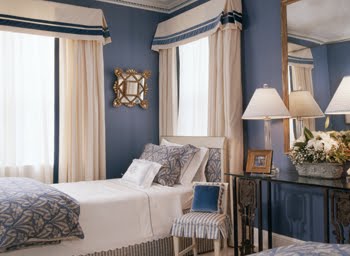 Blue bedroom by Kelley Proxmire with twin bed with a white scalloped bed cover, striped blue and white skirt and dusty blue and white blanket and pillow covers