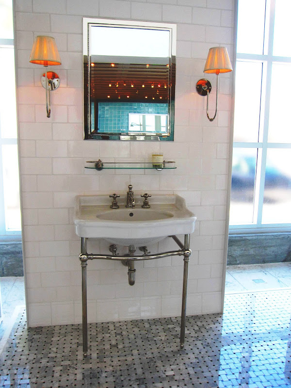 Wash basin sink, subway tile wall, chrome scones and marble basket weave mosaic floor