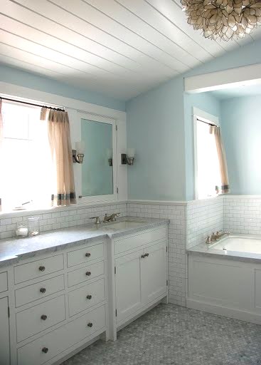Bathroom by Kevin Oreck with vaulted white wood plank ceiling, capiz shell Chandelier, light blue walls and hexagon mosaic tile floor