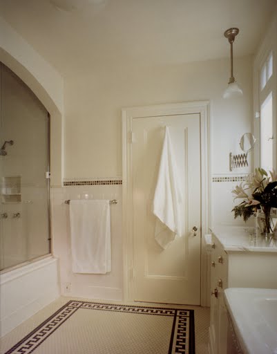 Classic white bathroom by Kevin Oreck with white tile floor with a black borders and trim
