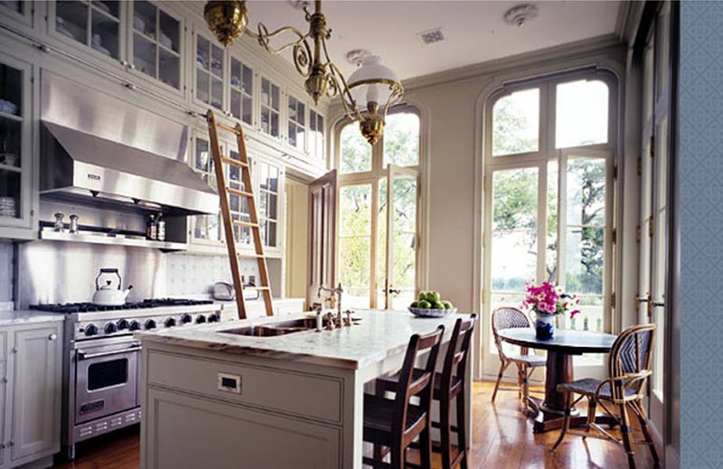 Gourmet Virginia kitchen by Peter Pennoyer with wood ladder to reach custom glass cabinets