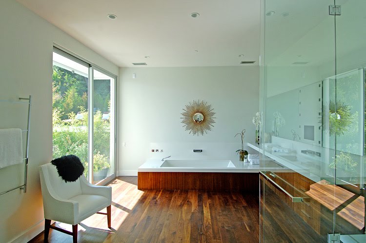 Master bathroom in a modern Beverly Hills home by Meridith Baer & Associates with stained walnut floor and a spa tub