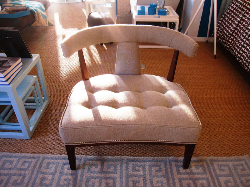 Extra wide upholstered chair with tufted seat, curved T-back and oak stained legs in the Jonathan Adler store 