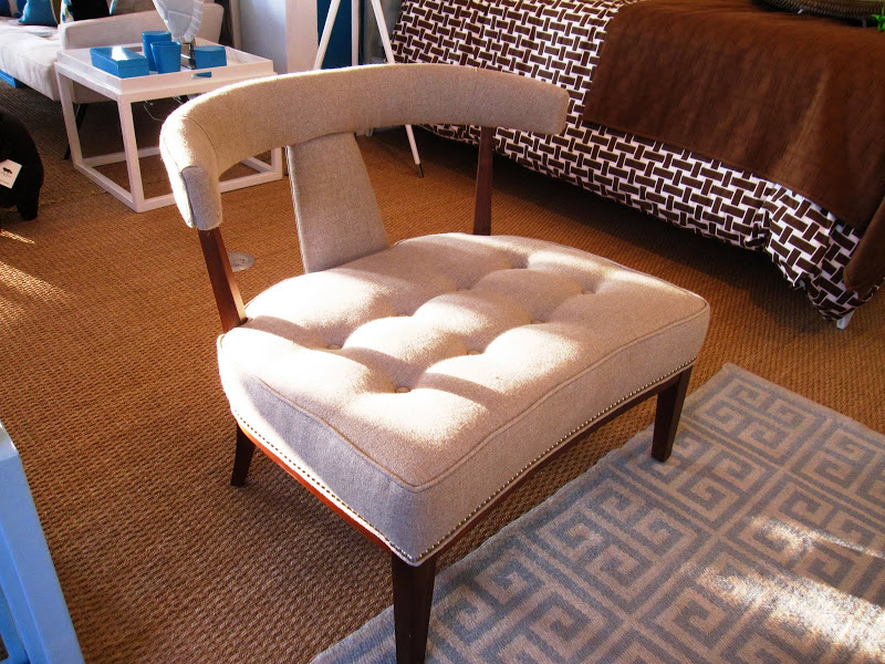 Extra wide upholstered chair with tufted seat, curved T-back and oak stained legs in the Jonathan Adler store 